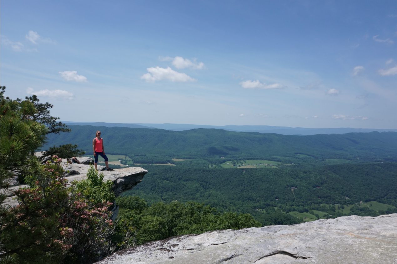 Writer Jessica Dixon wearing red on an outcrop at McAfee Knob